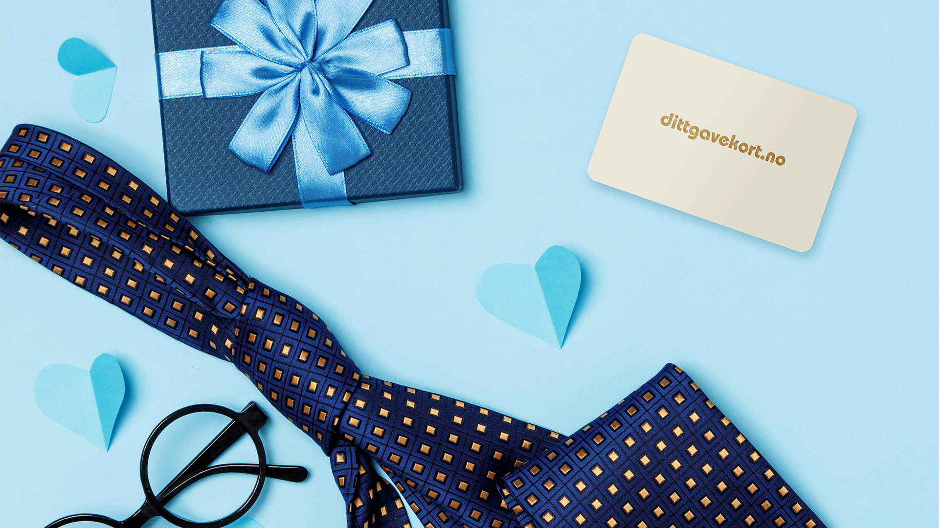 Dittgavekort på blå bakgrunn omringet av blå gaveeske, briller, blå hjerter og slips