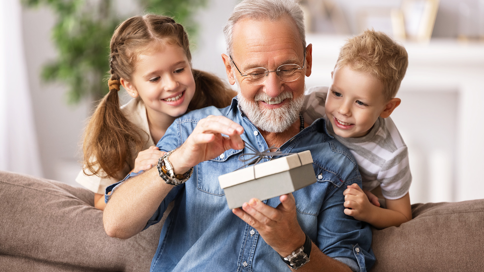 Bestefar åpner gave og barnebarn som ser på