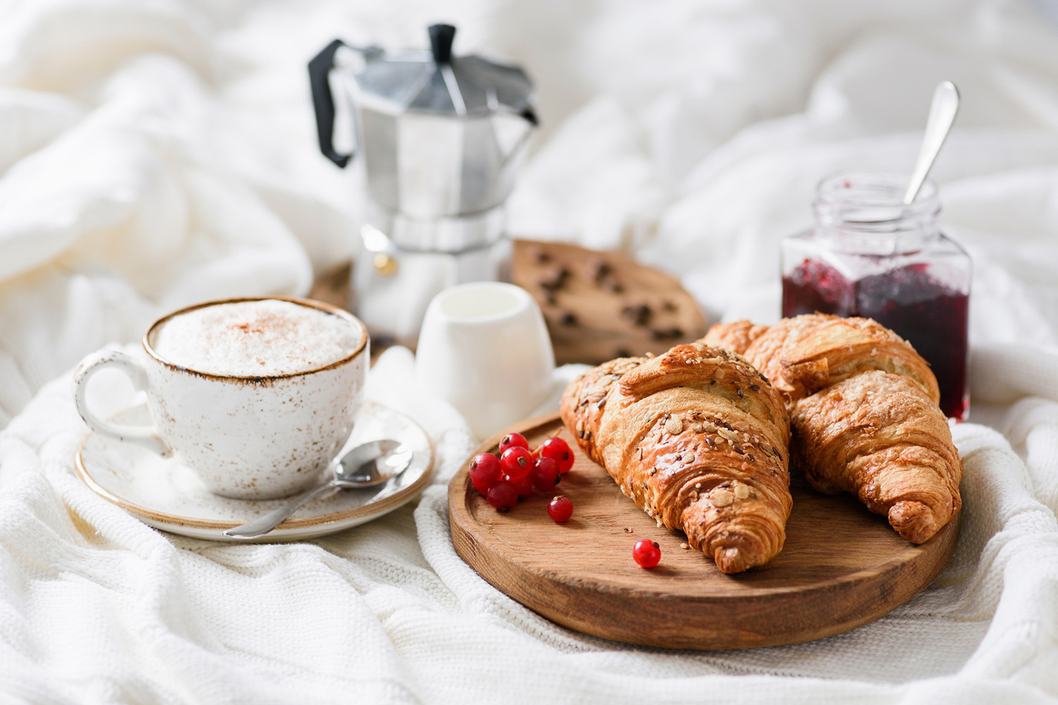 Croissanter og kaffe på sengen - en deilig frokost med varme bakverk og en dampende kopp kaffe